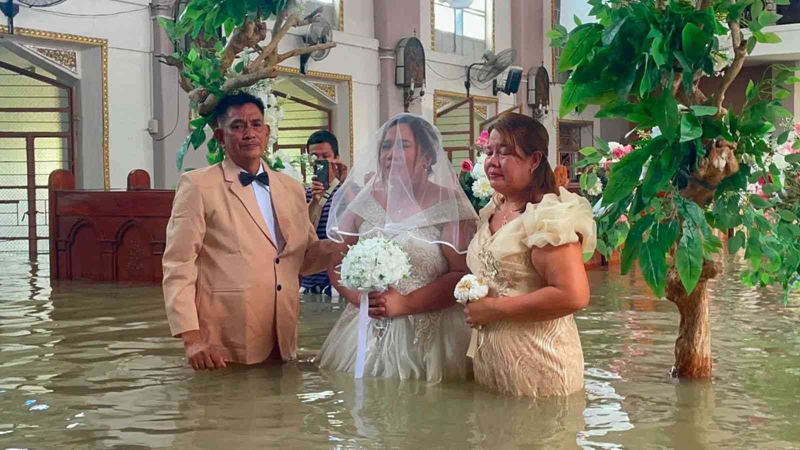 PHOTOS: Couple gets married in flooded church as bride wades through waist-deep water