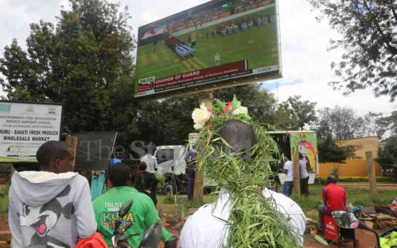 Elated residents follow swearing-in ceremony on giant screens outdoors and TV