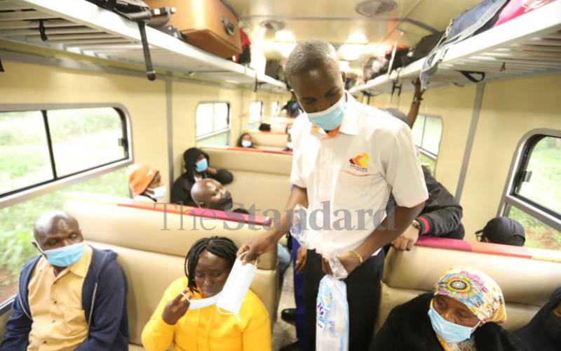 Kenya Railway official distributing face masks.