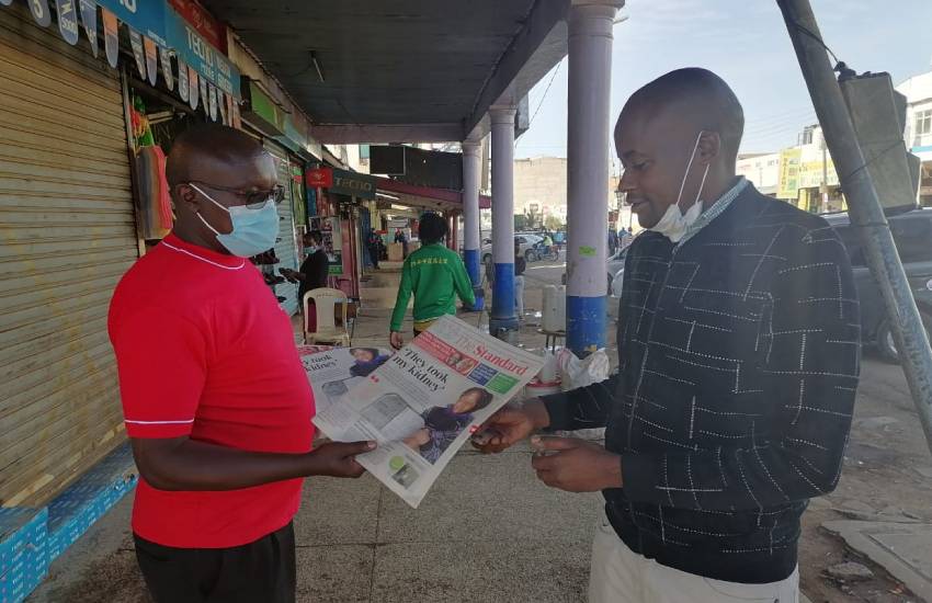 A reader buys a copy of The Standard.