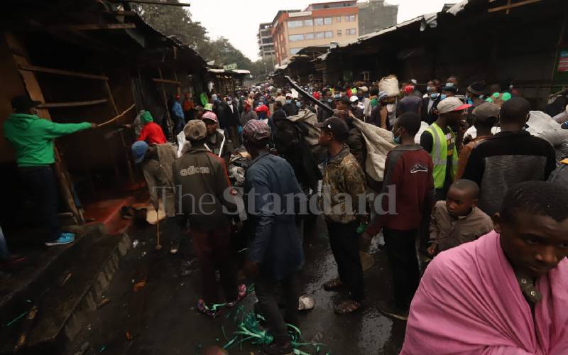 Traders look on at razed section of Gikomba