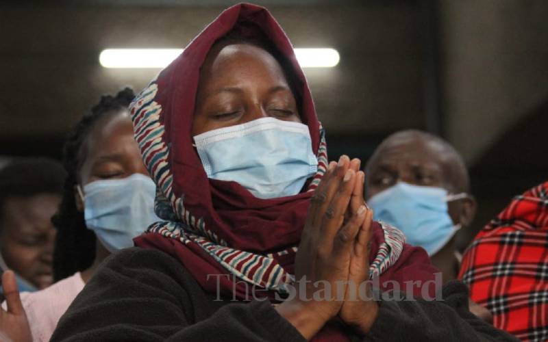 Woman in prayer at at Moi Sports Centre.