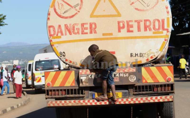 A boy hangs on an oil tanker (Obote Rd, Kisumu)