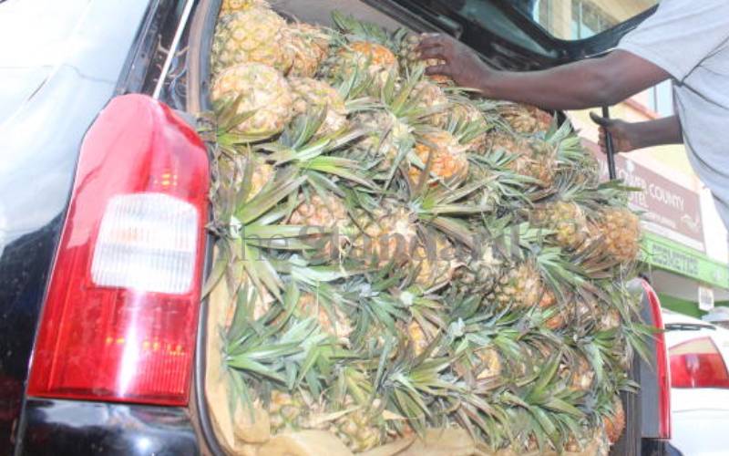 Trader selling pineapples from his Probox, Kisii.