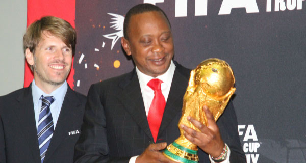 President Uhuru Kenyata holds the World Cup trophy at Kempinski hotel during the world trophy tour organised by Coca Cola. With him is a Fifa official Pekka Odziozola. [PHOTO:JONNAH ONYANGO]