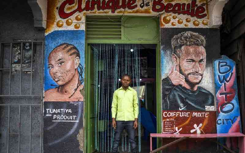 Palou, 27, poses in front of his salon in Goma.