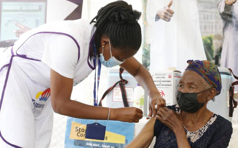 A healthcare worker vaccinates an elderly woman during the Launch of Covid-19 Mass Vaccination Drive at Dagoretti Deputy County Commissioner’s Office. [Stafford Ondego, Standard]