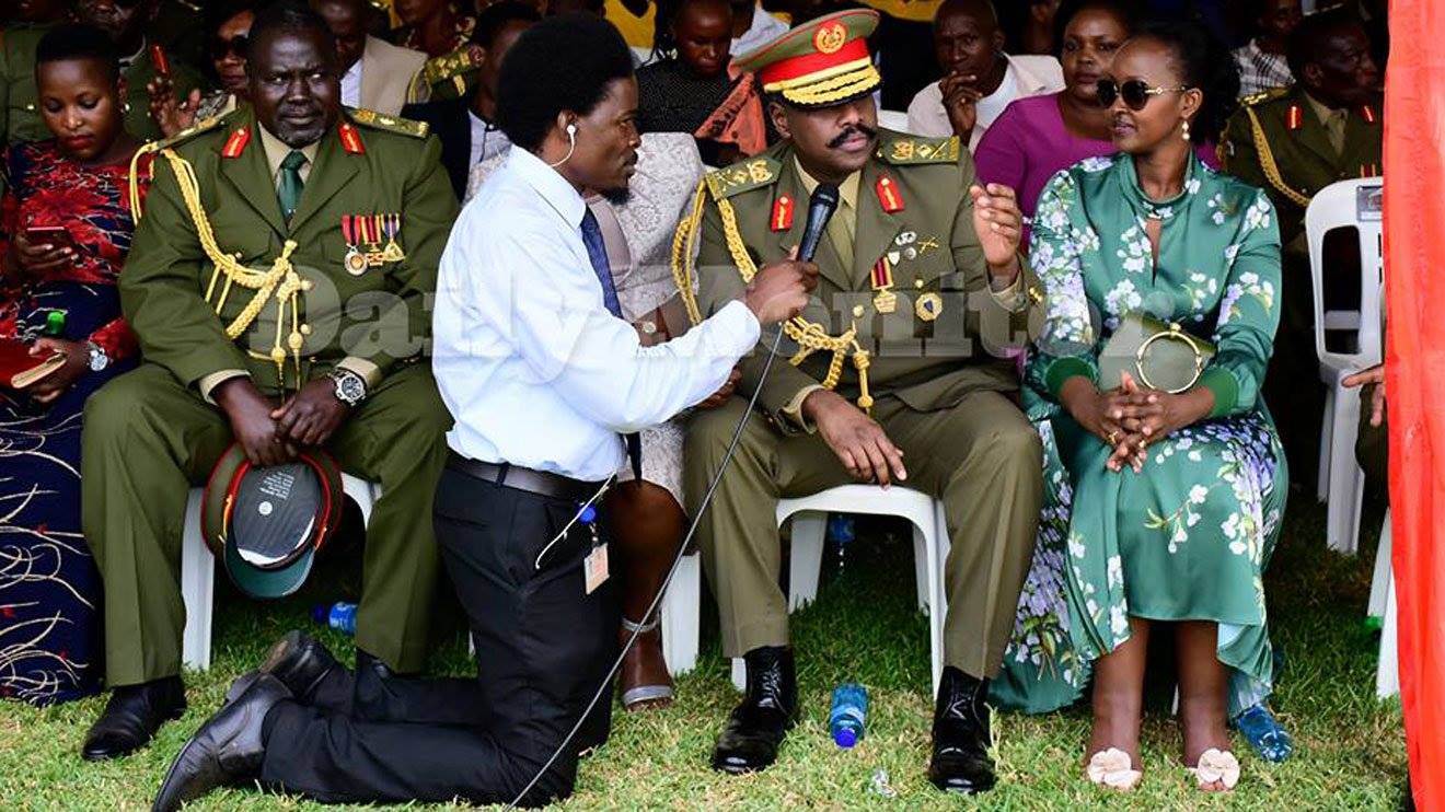 Photo of journalist kneeling down to interview Uganda ...