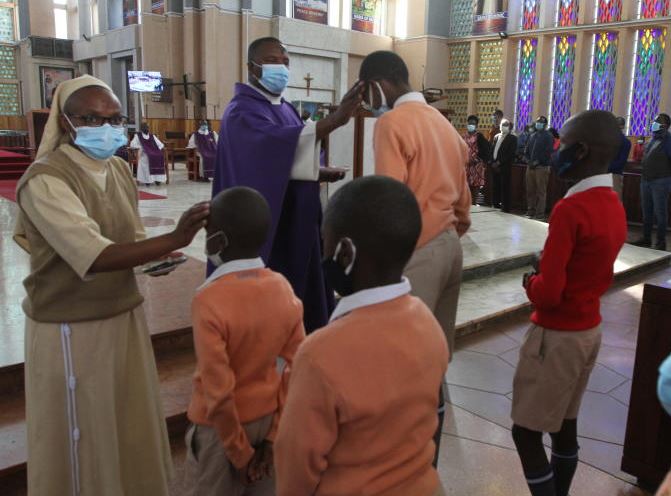 Fr. Simon Kinyanjui smears ash on pupils. 