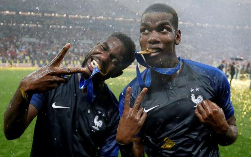 France's Paul Pogba and Samuel Umtiti bite their m